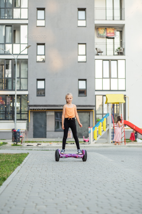 Child girl riding in on gyroscooter. Hobbies and active lifestyle in city. - Stock Photo - Images