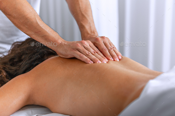 Overhead view of woman receiving back massage from therapist in