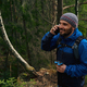 Happy man hiking in the woods and talking on smartphone - PhotoDune Item for Sale
