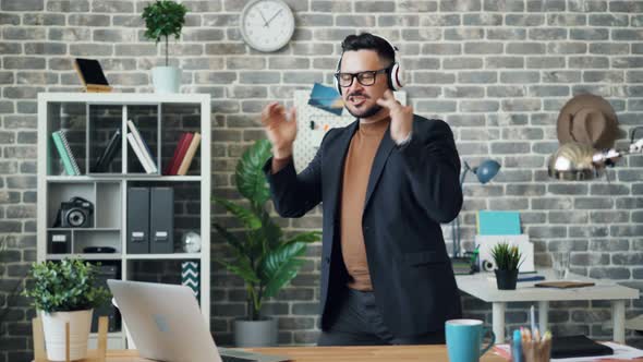 Funny Businessman Relaxing at Work Listening To Music in Headphones Dancing alt