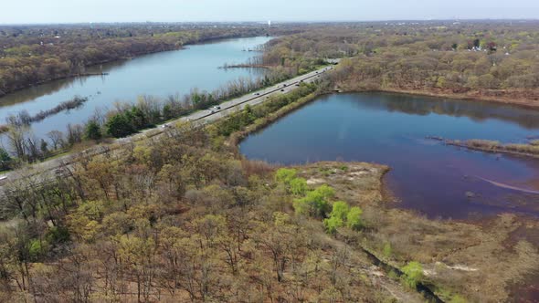 An aerial view over some reflective lakes during the day. The drone tilt up, pan left and dolly in t alt