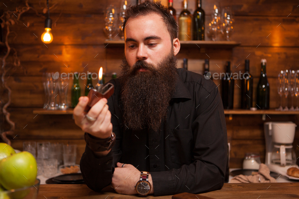 Handsome young bartender playing with his custom made lighter.