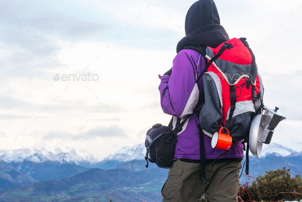A well-equipped hiker with a red backpack