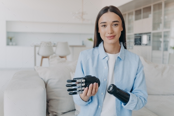 Young girl with prosthetic arm showing high tech bionic prosthesis. Modern people with disabilities