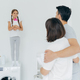 husband and wife embrace and talk to small girl standing on washer with bottle of detergent - PhotoDune Item for Sale