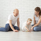 Baby child with hearing aids and cochlear implants plays with parents on floor. Deaf and - PhotoDune Item for Sale