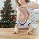 Mother fixing her daughter&#39;s cochlear implant hearing aid on christmas tree background - deafness - PhotoDune Item for Sale
