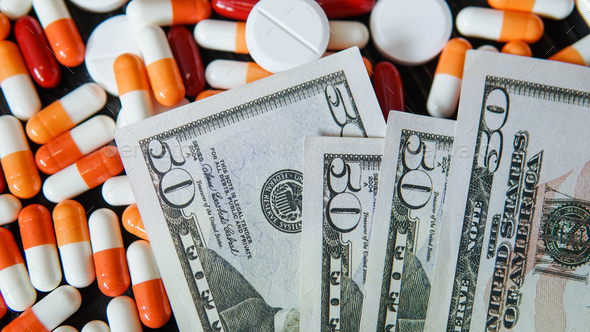 Medicine pills capsules with money dollar. Cost of the healthy life. Expensive medicine
