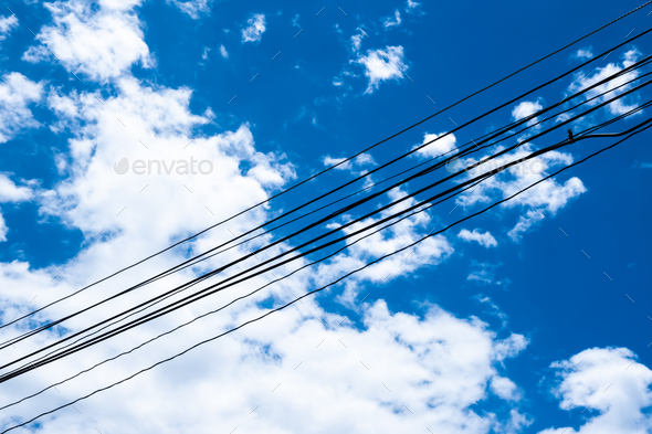 The background of electrical wire cable with blue sky for energy power consumption concept and idea