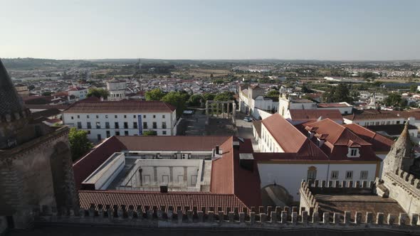 Drone flying over Evora Cathedral with old roman ruins temple in background, Portugal.