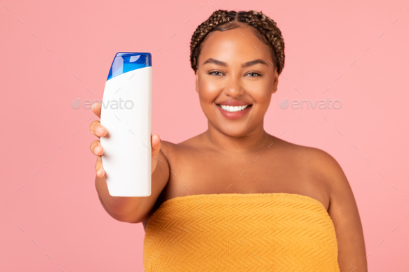 Happy Oversized Black Lady Showing Shampoo Bottle Over Pink Background