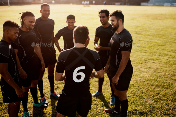 Cropped shot of a diverse group of sportsmen standing together before playing rugby during the day