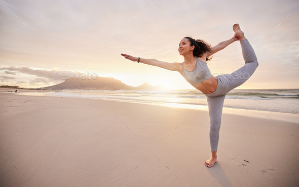 Find yourself through yoga. Shot of a young woman practicing yoga on the beach.