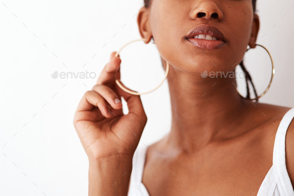Studio shot of an unrecognizable woman wearing gold hoop earrings