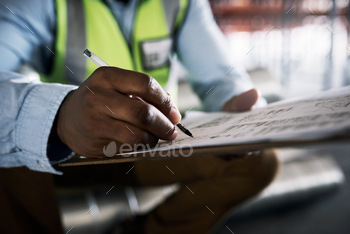 Shot of an unrecognisable builder filling out paperwork at a construction site