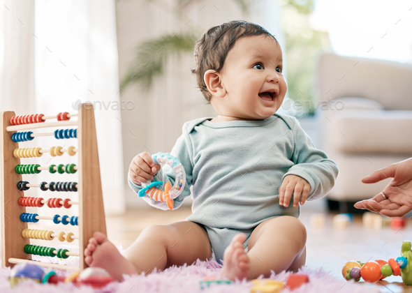 Babies know how to have a good time. Shot of an adorable baby playing with toys at home.