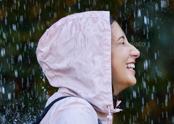 The rain makes me feel alive. Shot of an attractive young woman standing alone outside in the rain.