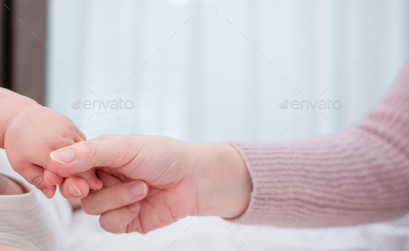 Hands holding of mother parent soft touch newborn baby fingers love family concept.