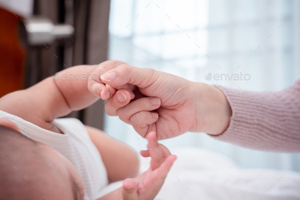 Hands holding of mother parent soft touch newborn baby fingers love family concept.