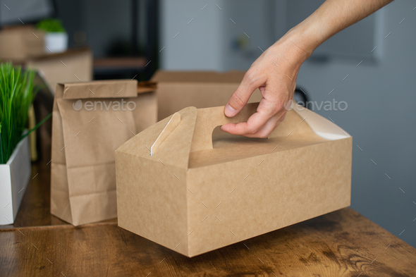 Craft food box with a handle in a person\'s hand