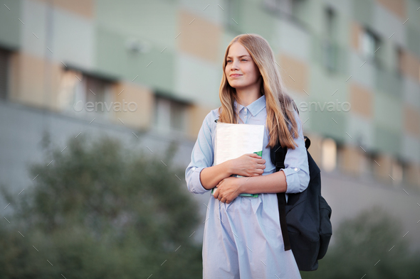 First day back to school. School girl portrait of teen model with backpack, textbooks notebooks