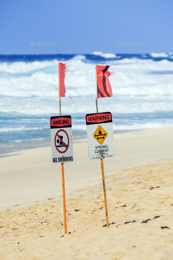 Beach signs prohibiting swimming and warning of strong currents at the beach