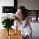 Beautiful woman putting fresh white flowers into a vase - PhotoDune Item for Sale