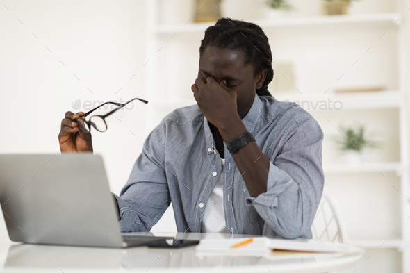 Black Freelancer Suffering Eyes Strain, Taking Off Glasses And Massaging Nose Bridge