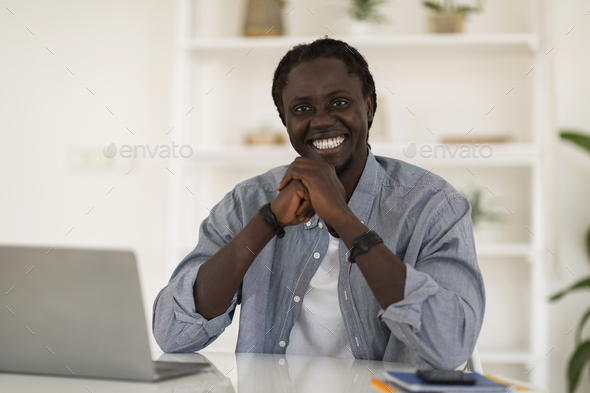 Freelance Career. Cheerful Young Black Freelancer Guy Sitting At Desk With Laptop