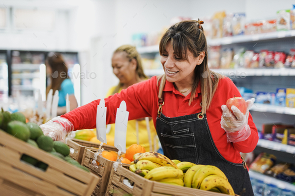 Happy latin woman working inside mini market