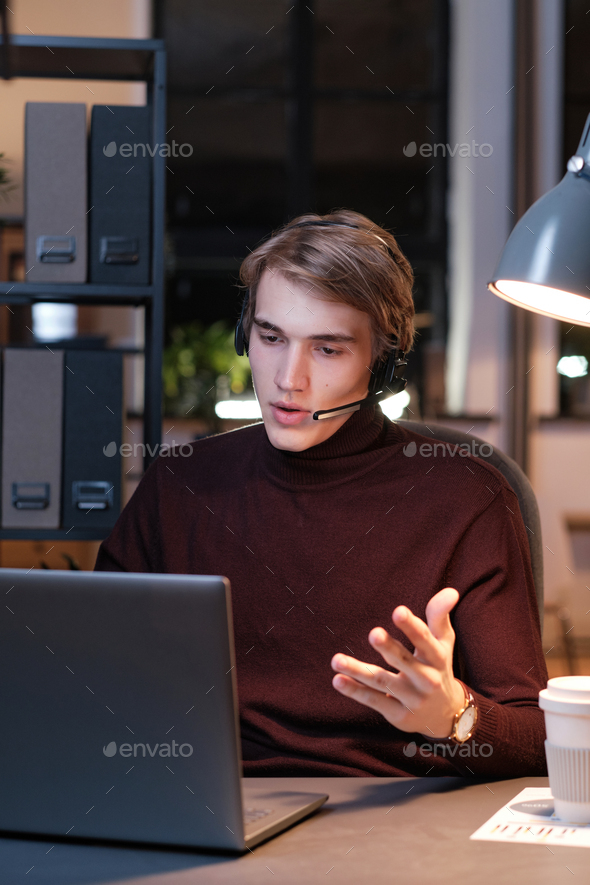Hotline operator working with client at night Stock Photo by Media_photos