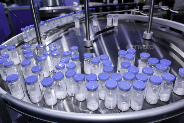 medicine glass bottle in pharmaceutical production line on conveyor belt in manufacturing.