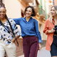 Multiracial females laughing during stroll near building - PhotoDune Item for Sale