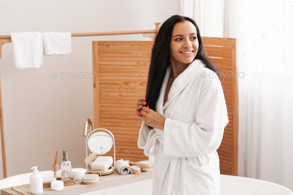 Happy Black Female Touching Hair Smiling Looking Aside In Bathroom - Stock Photo - Images