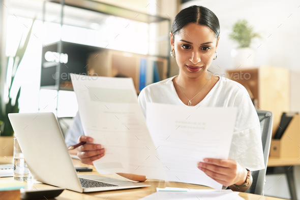 These facts do seem to correlate. Shot of a young businesswoman reviewing paperwork at work. - Stock Photo - Images