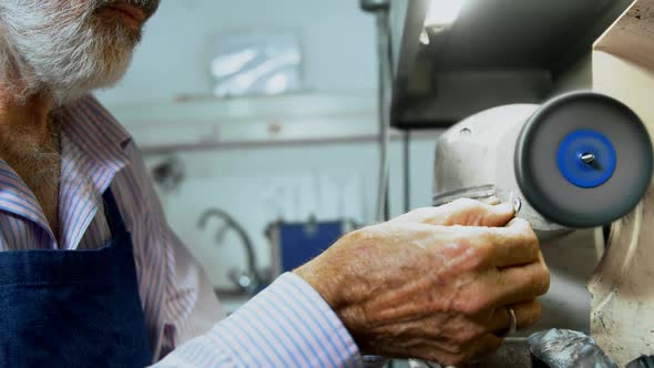 Goldsmith polishing ring in workshop alt