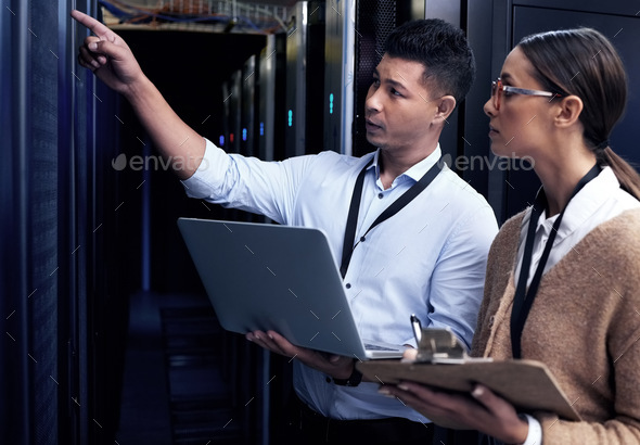 Its not safe until IT support says so. Shot of two technicians working together in a server room.