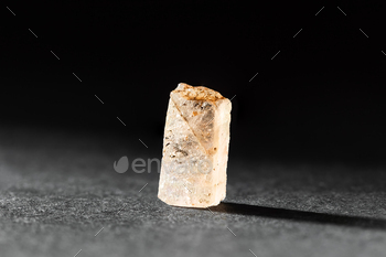 Rough uncut Yellow Topaz stone sample on black