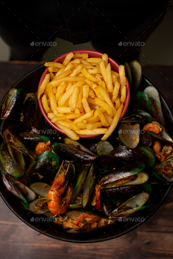 Steamed mussels with paprika and wine. Served with french fries. Seafood. sea shells aphrodisiac f