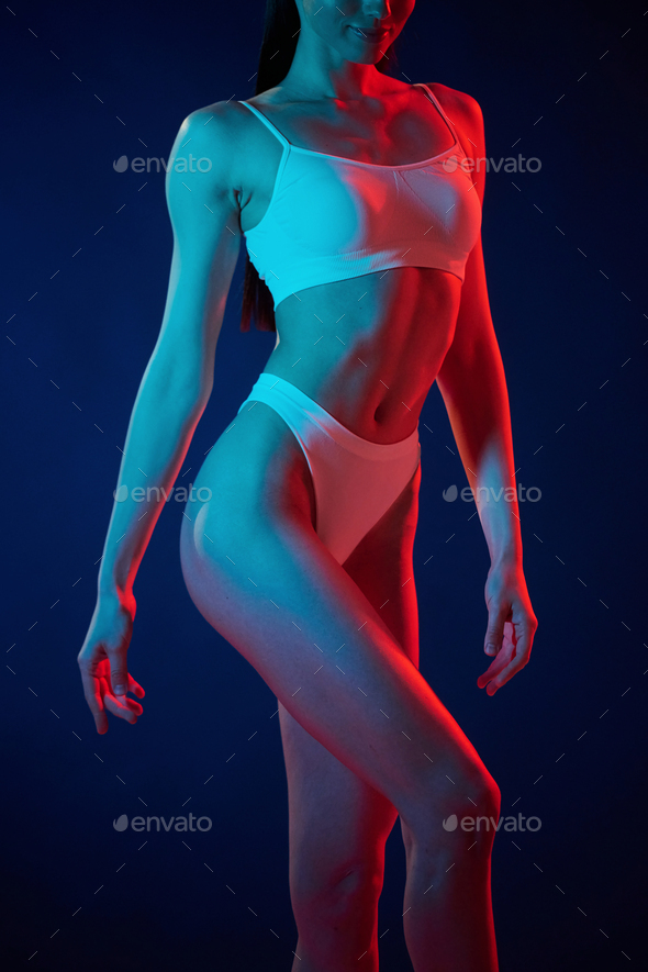 White underwear. Young woman is in the studio with neon lights - Stock Photo - Images