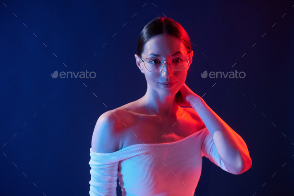 Beautiful look. Portrait of young woman that is indoors in neon lighting - Stock Photo - Images