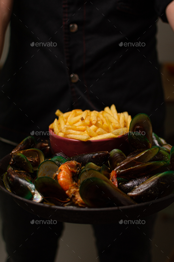 Steamed mussels with paprika and wine. Served with french fries. Seafood. sea shells aphrodisiac f