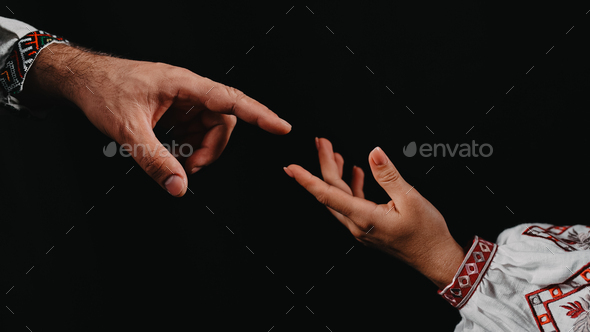 Idea of earth creation. Ukrainian hands reaching out, pointing finger together on black background