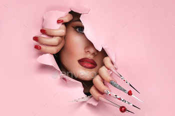 Portrait of a beautiful woman with art make up in glamorous style, creative long nails. 