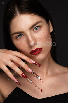 Portrait of a beautiful woman with classic make up in glamorous style, creative long nails.