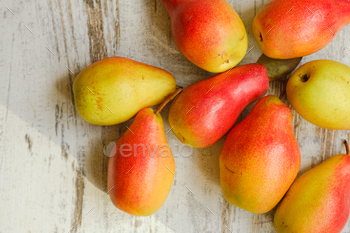 Fresh ripe organic red and yellow pears on a wooden table. 