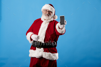 Santa Claus using a mobile phone on blue background