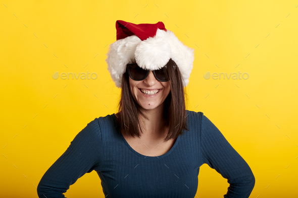 a girl makes a fool of herself in a Santa Claus hat with a yellow background