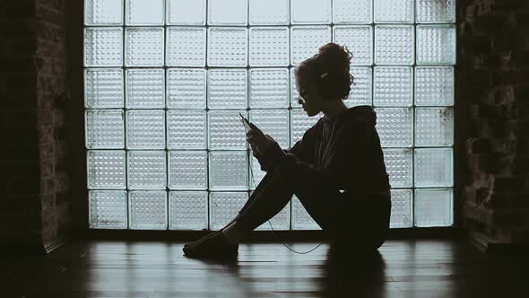 Girl Sitting on the Floor Watching Video on Phone  alt