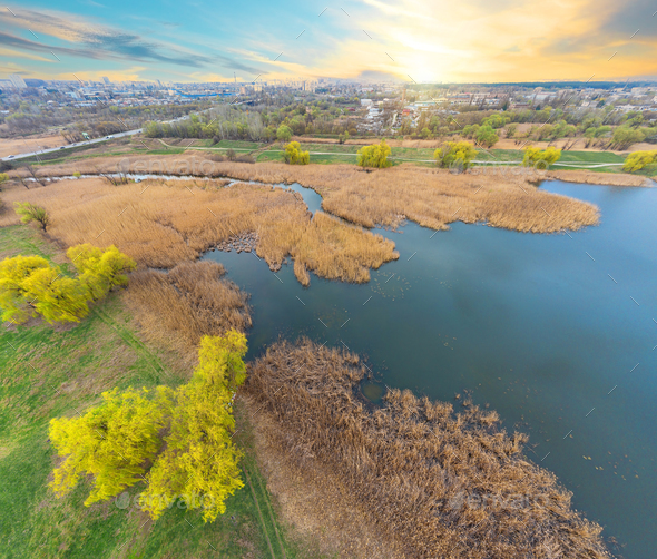 View of river and green bank from height at sunset - Stock Photo - Images